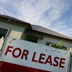 A house with a 'for lease' sign in front