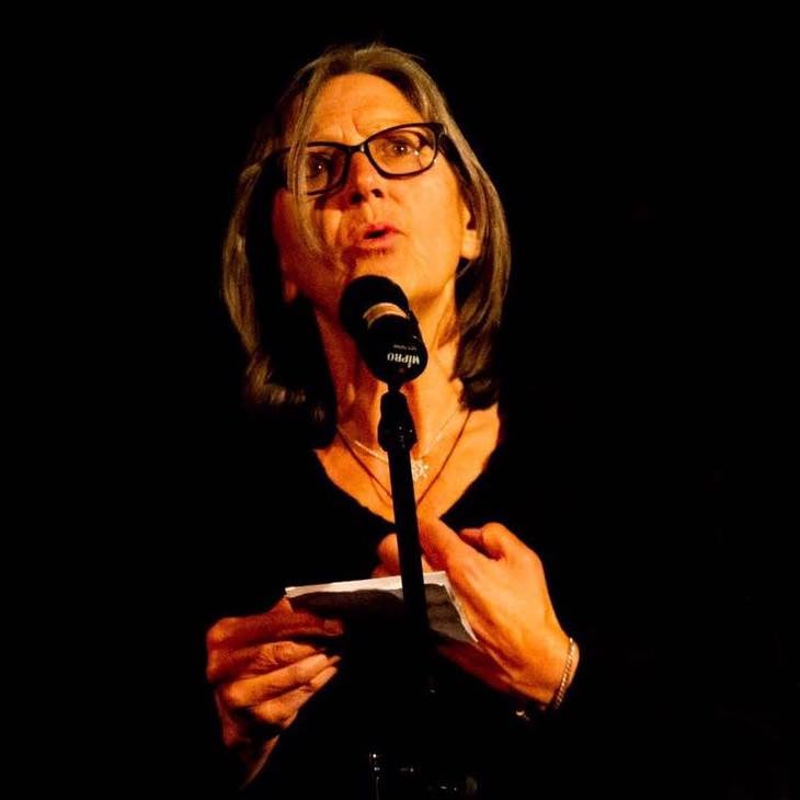 Christine Burrows doing a reading at a microphone