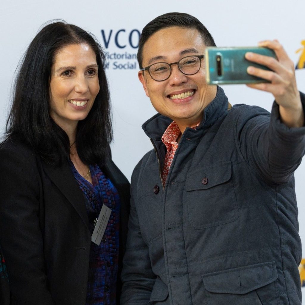 Two people holding up a phone to take a selfie