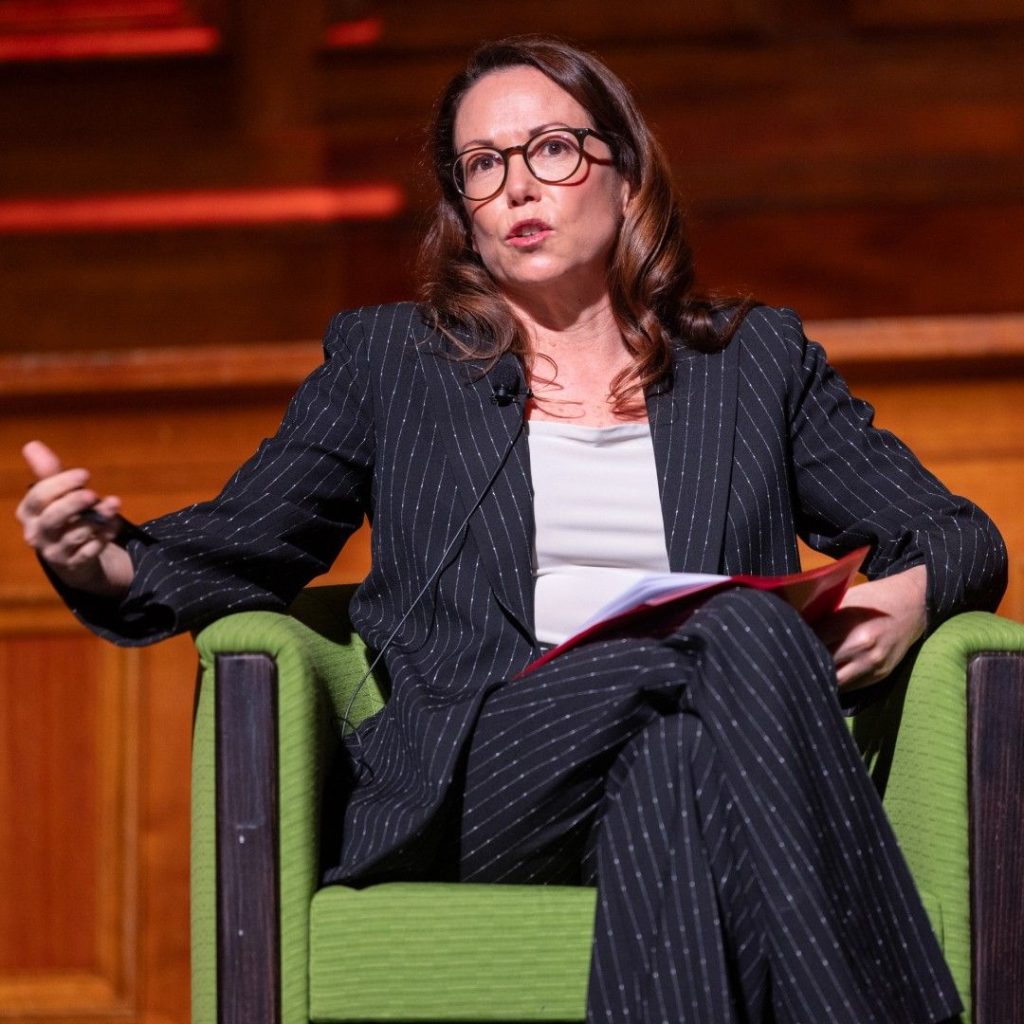 Treasurer Jaclyn Symes, speaking on stage