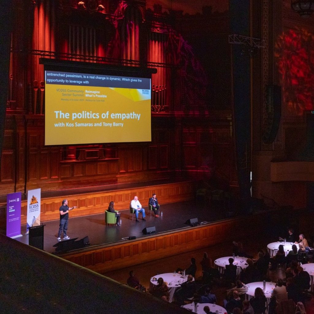 Three people and an Auslamn interpreter on stage