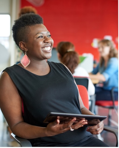 A woman smiling and holding a tablet